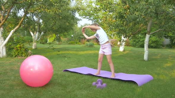 The Little Girl Doing Physical Exercises in Garden alt