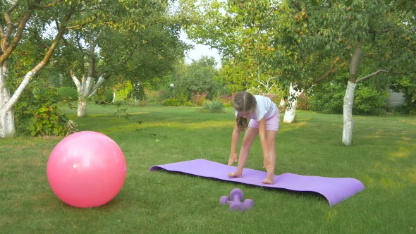 A Cute Girl Doing the Exercises in the Garden alt