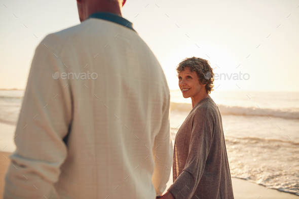 Mature couple walking together on sea shore
