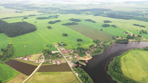 View From the Height of the Lake in a Green Field in the Form of a Horseshoe and a Village in the alt