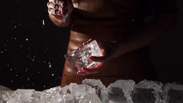 Barman with Strong Arms Crushing Ice with Special Fork, Pieces of Ice Flying Everywhere