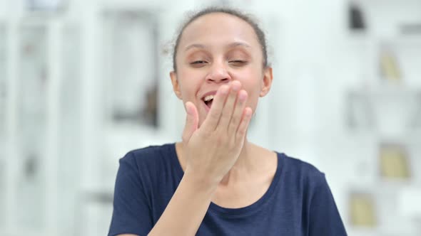 Portrait of Happy African Woman Giving Flying Kiss  alt