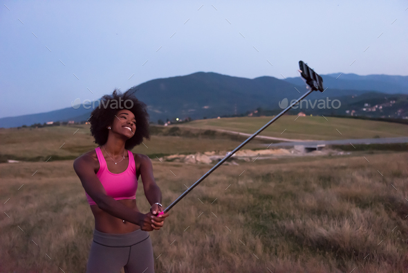 black woman photographing herself in nature - Stock Photo - Images