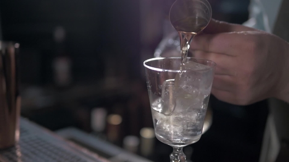 Bartender Is Making Cocktail at Bar Counter, Adding Some Bitter in the Shaker alt
