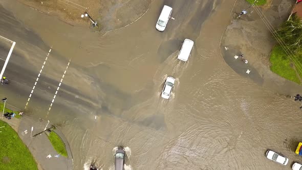 Aerial view of traffic cars driving on flooded road with rain water. alt