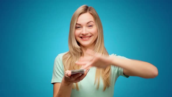 Young Woman Showing Gesture of Wasting Money Against Blue Background Materialist Shopping Concept alt