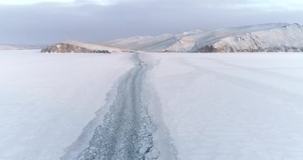Drone Following a Icebreaker on Surface of Frozen Lake Baikal  White Snow Travel concept alt