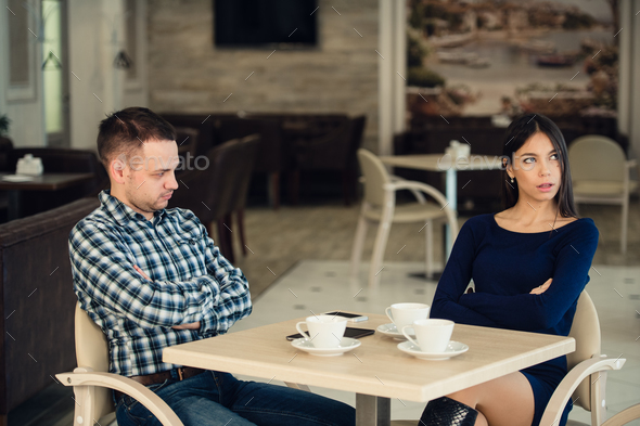 Young unhappy married couple having serious quarrel at cafe - Stock Photo - Images