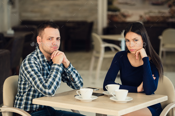 Young unhappy married couple having serious quarrel at cafe - Stock Photo - Images