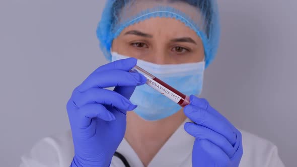 Nurse Holding Test Tube with Positive Coronavirus 