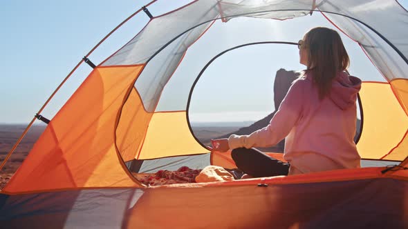 Beautiful Young Woman Performing Spiritual Yoga Pose Sitting in Tent at Sunrise alt