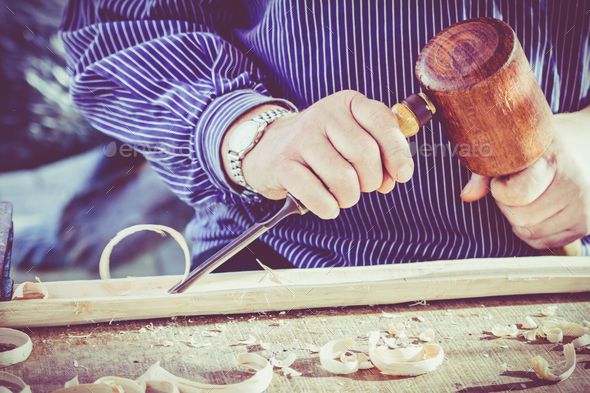 hands of the craftsman carve a bas-relief with a gouge. Craftsma Stock Photo by EwaStudio