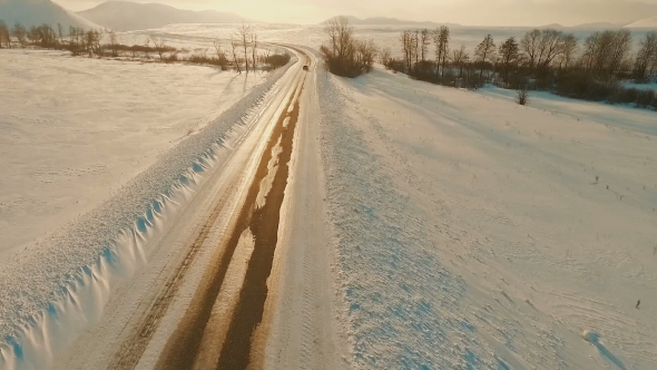 Car Driving on Icy Road at the Dusk
