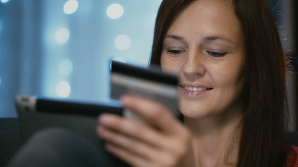 Woman Shopping Online Using a Credit Card Tablet Pc and Mobile App alt