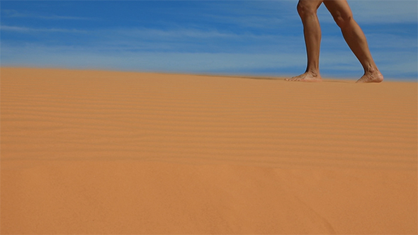 Women's Feet Walking on a Sandy Desert