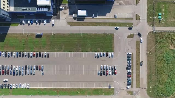 Aerial Survey of Parking Lot Near the Factory, Around Which the Green Lawns. Car Rides on a Parking alt