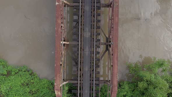 Rusty railway bridge over the river from above 4K aerial video alt