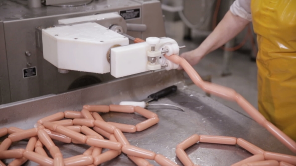 Food Factory. Worker Produces Sausages on a Automated Food Production Equipment. alt