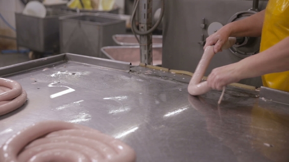 Food Factory. Worker Produces Sausages on a Automated Food Production Equipment. alt