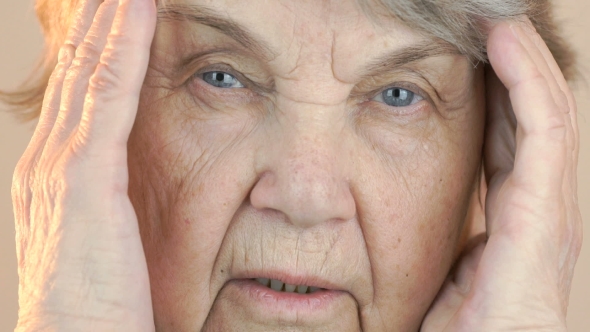 Old Woman Holding Head with Hands Due To Headache