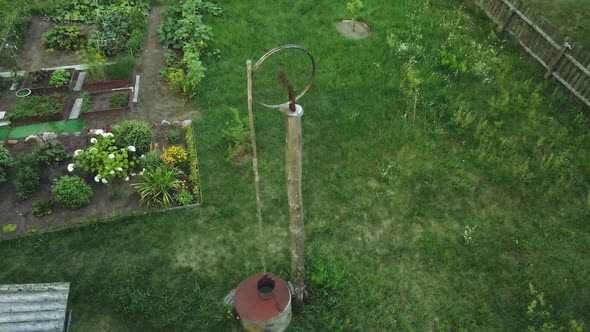Flight Over The Old Village Well. Lifting Mechanism From The Wheel. Aerial Photography. alt