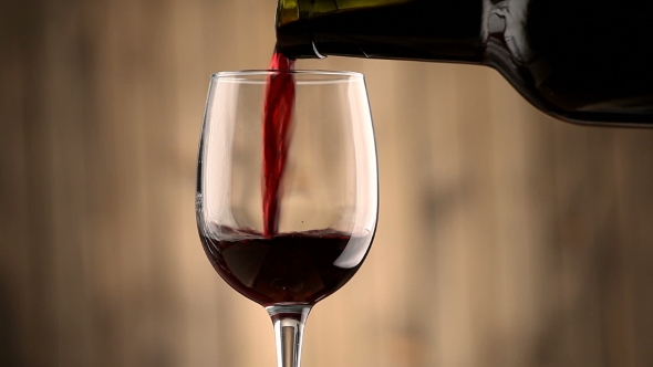 Pouring Red Wine Into a Glass. alt