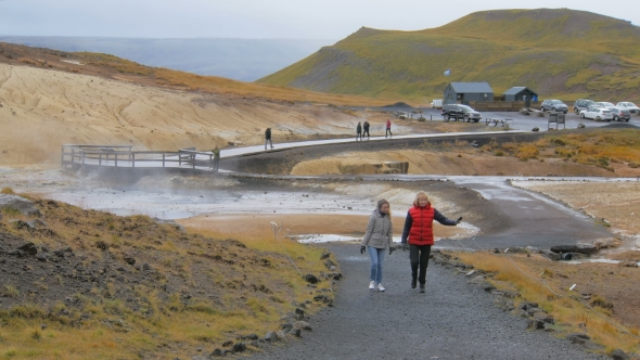 Two Blonde Women Are Walking and Looking To a Side in Geothermal Area Krysuvik in Iceland