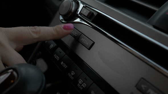 Woman Typing Radio Button in Car alt