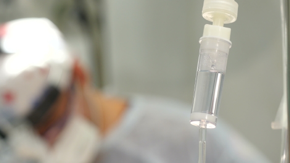 Intravenous Drip, Surgical Light and Surgeons Operating