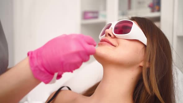 Cosmetologist Makes Laser Facial Hair Removal Beautiful Woman in Beauty Salon alt