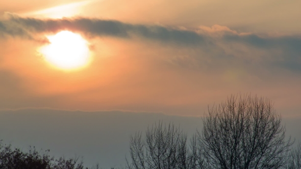 Sunset Over the Trees and Clouds. alt