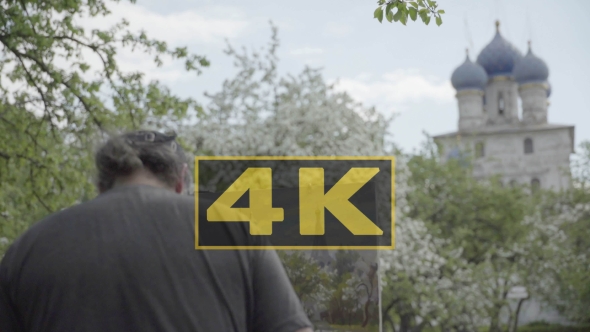 Concept Religion. Skilled Artist Draws Temple in Flowering Garden. Follow Focus