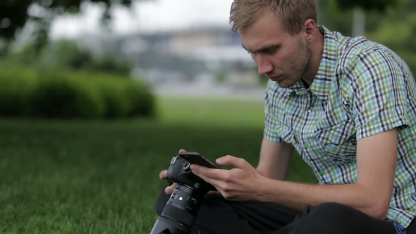 Man Sets the Camera Before Taking a Picture with Your Smartphone