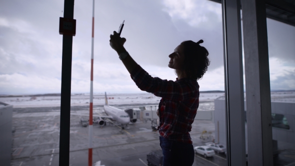 Beautiful Brunette Girl with Short Hair at the Airport. She Is Happy. Since She Was Going on