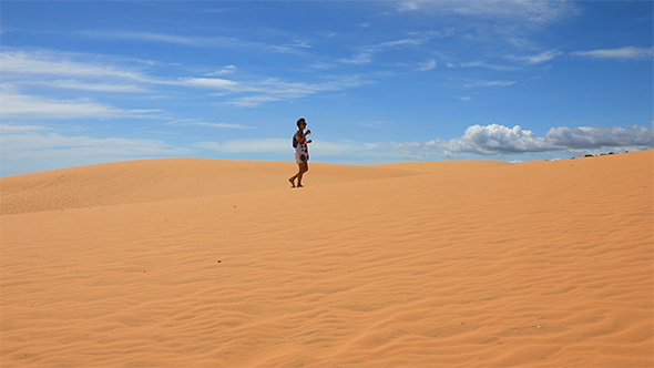 Woman Walking Across The Sand Dunes