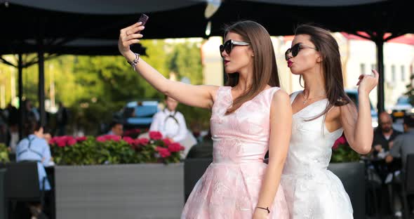 Two Fashionable Woman with Red Lips Making Self Portrait at Smart Phones