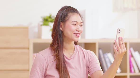 Asian girl contacts with friends through video call. Mobile distance virtual meeting alt