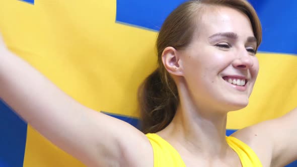 Swedish Young Woman Celebrates Holding the Flag of Sweden in Slow Motion alt