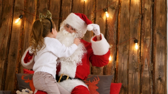 Cute Little Girl Pulling Santa's Beard To Check If It's Real Sitting on His Lap alt