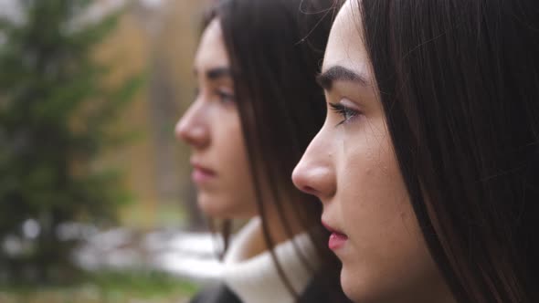 Outdoor portrait of Two Serious Twin Sisters' Profile