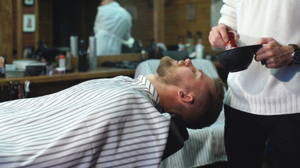Client During Beard Shaving in Barber Shop alt
