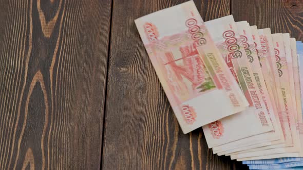 Stack of Russian Rubles Banknotes Dropping on Wooden Surface and Sliding