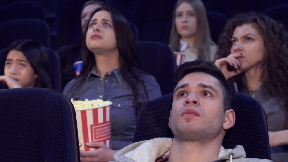 People Watch Serious Film at the Movie Theater alt