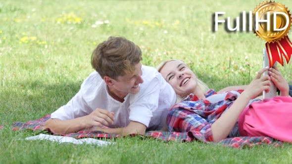 Young Couple Lying on a Grass Reading Students alt