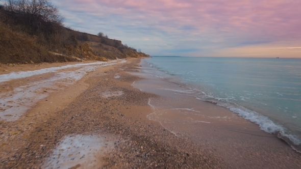 Epic Flying Drone To Over the Winter Beach During a Beautiful Pink Sunset. . alt
