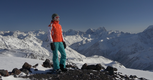 Female Skier Enjoys the View of Winter Mountains