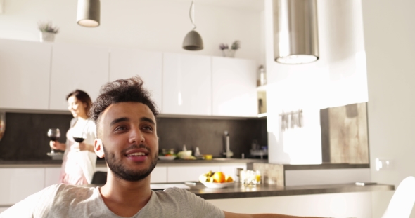 Young Mixed Race Couple Morning, Happy Asain Woman Bring Wine Glasses To Hispanic Man Sitting Coach alt