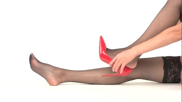 Woman Putting on Heel Shoes. alt