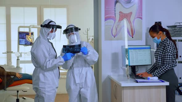 Slow Motion of Dentists with Overall Looking at Xray alt