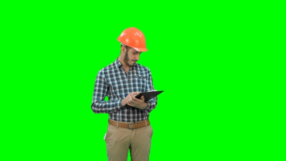 Civil Engineer Filing in Inspection Form on a Green Screen, Chroma Key alt